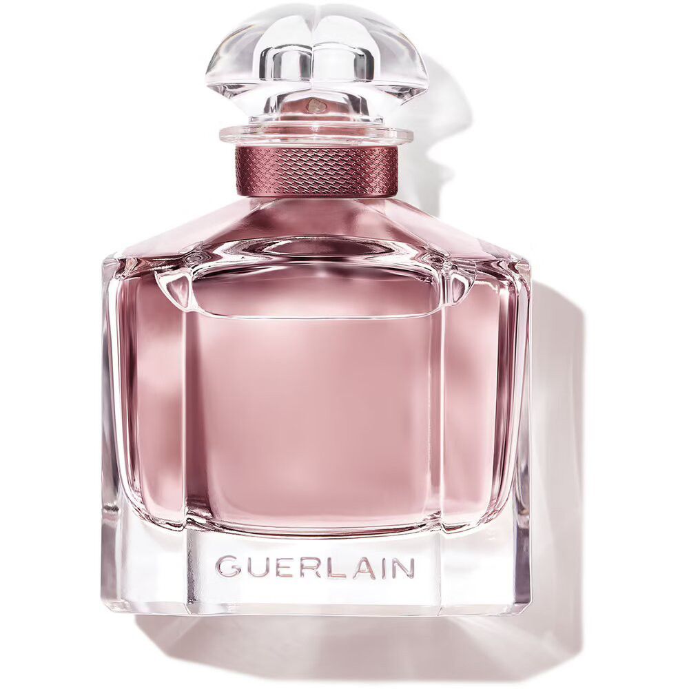 Rosa Parfümflasche mit quadratischem Sockel und transparentem Deckel. Aufschrift Guerlain auf dem Flaschenboden.