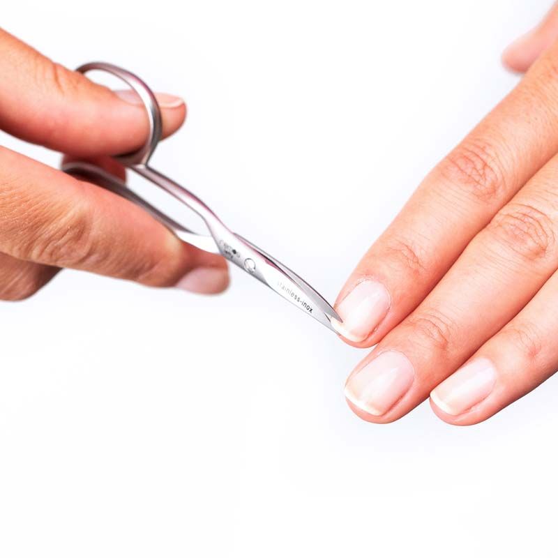 Nagelschere für Linkshänder in Anwendung. Hände schneiden einen Fingernagel. Marke REMOS, Schriftzug 'stainless-inox' sichtbar.