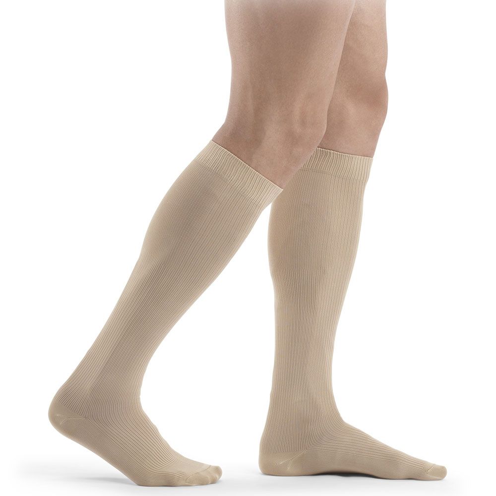 Beige Kniestrümpfe. Geripptes Material. Angedeuteter Fußbereich. Trägerbeine im Profil.