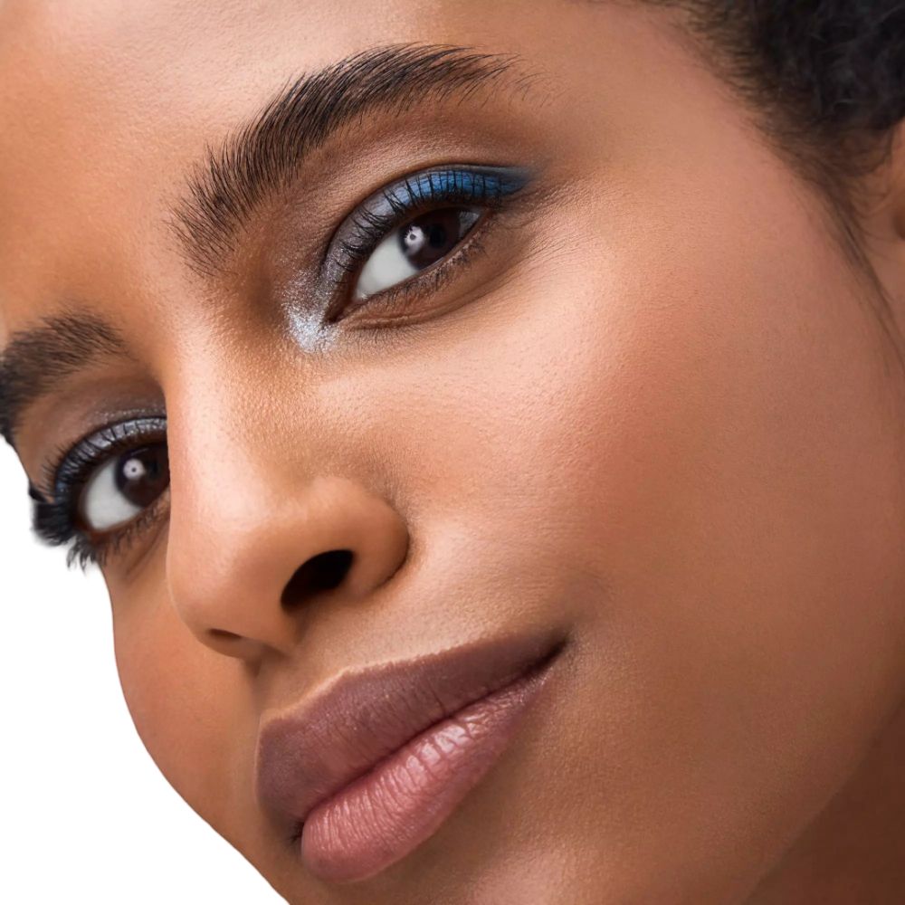 Nahaufnahme eines Gesichts mit geschminkten Augen. Blaue Lidschattenfarben. Person mit dunkler Haut und Lippen.