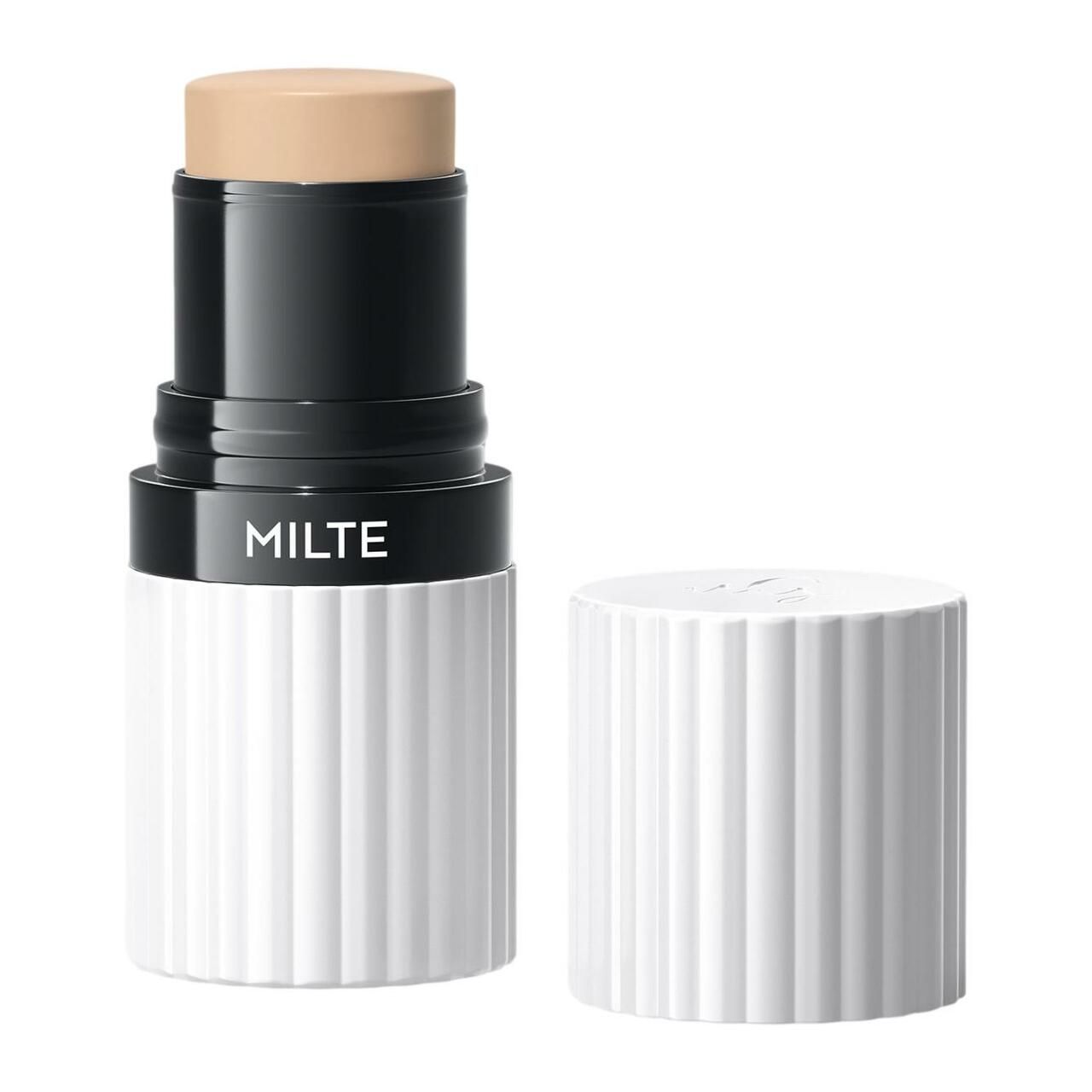 Foundation Stick MILTE, geöffnet. Beige Produktspitze, schwarzer Mittelteil mit MILTE-Schriftzug, weißer, geriffelter Behälter und Deckel.