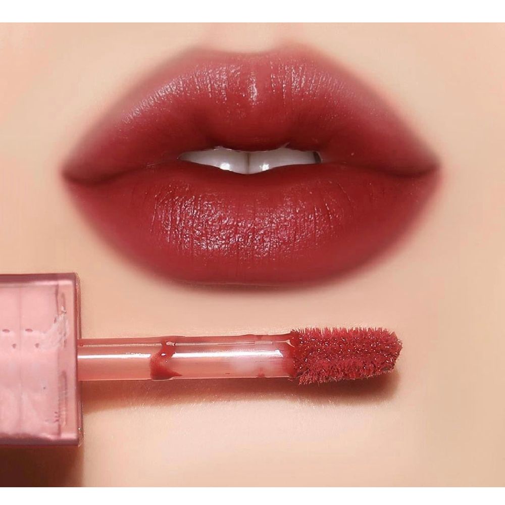 Nahaufnahme von Lippen mit aufgetragenem rotem Lipgloss. Applikator sichtbar. Hautton.