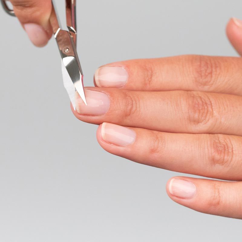 Nagelschere mit Turmspitze, silberfarben, in Anwendung. Schneidet einen Fingernagel.