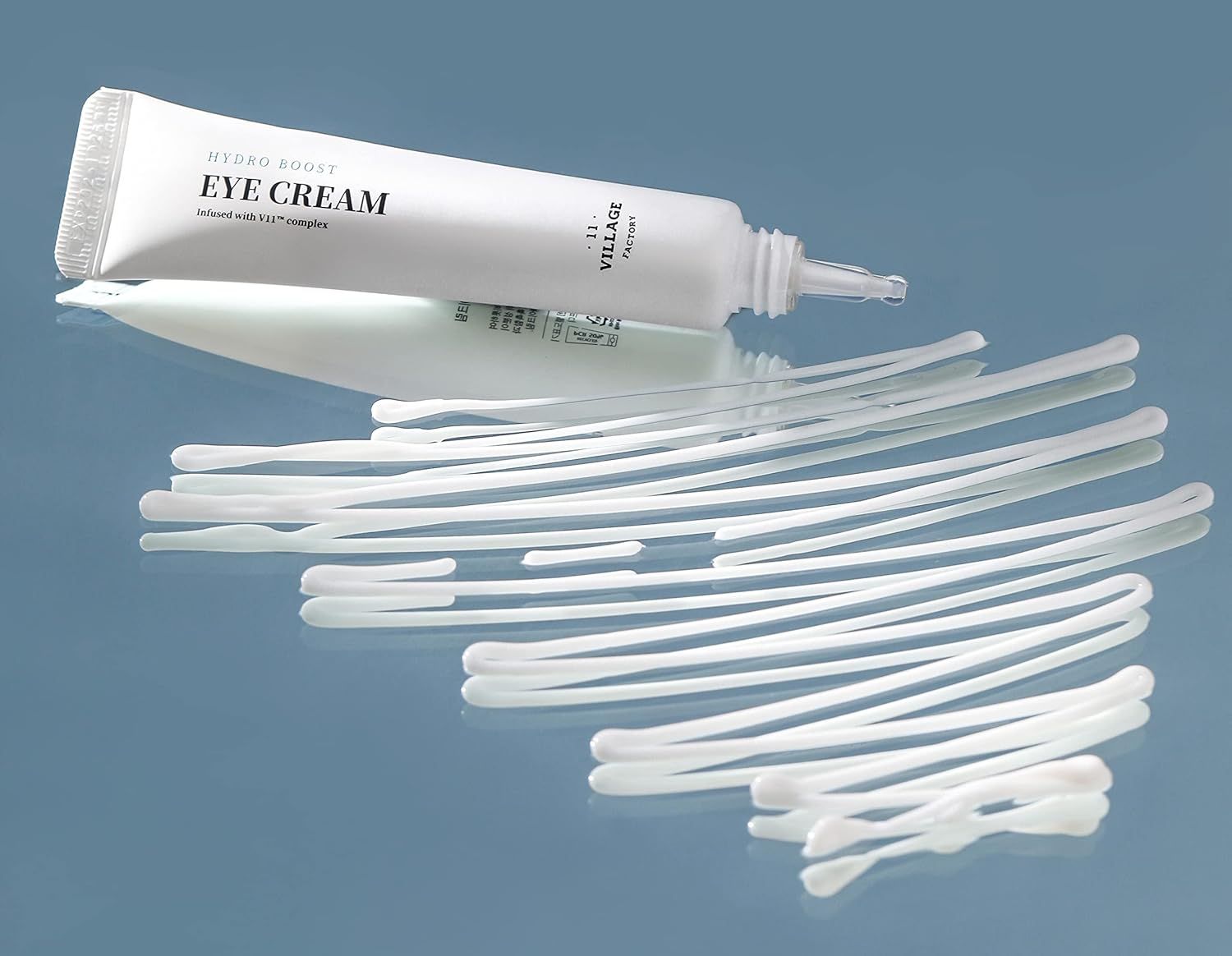 Weiße Tube Augencreme und Wattestäbchen auf spiegelnder Oberfläche. Produktname: EYE CREAM.