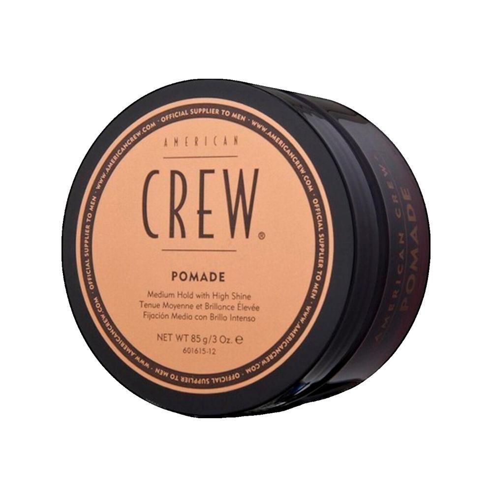 Runde, schwarze Dose mit braunem Deckel. Aufschrift: AMERICAN CREW. Pomade. Netto 85 g/3 Oz.