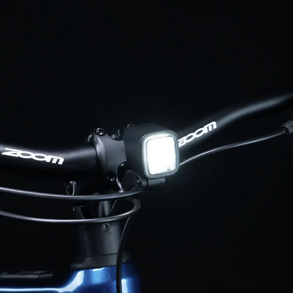 Fahrradlenker mit Scheinwerfer. Scheinwerfer mit weißem Licht, Lenker mit Zoom-Logo.