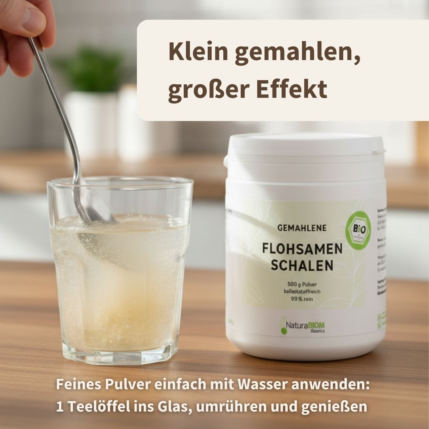 Glas mit Pulver in Wasser. Behälter mit Aufschrift: Gemahlene Flohsamenschalen, 99% rein. Löffel im Glas.