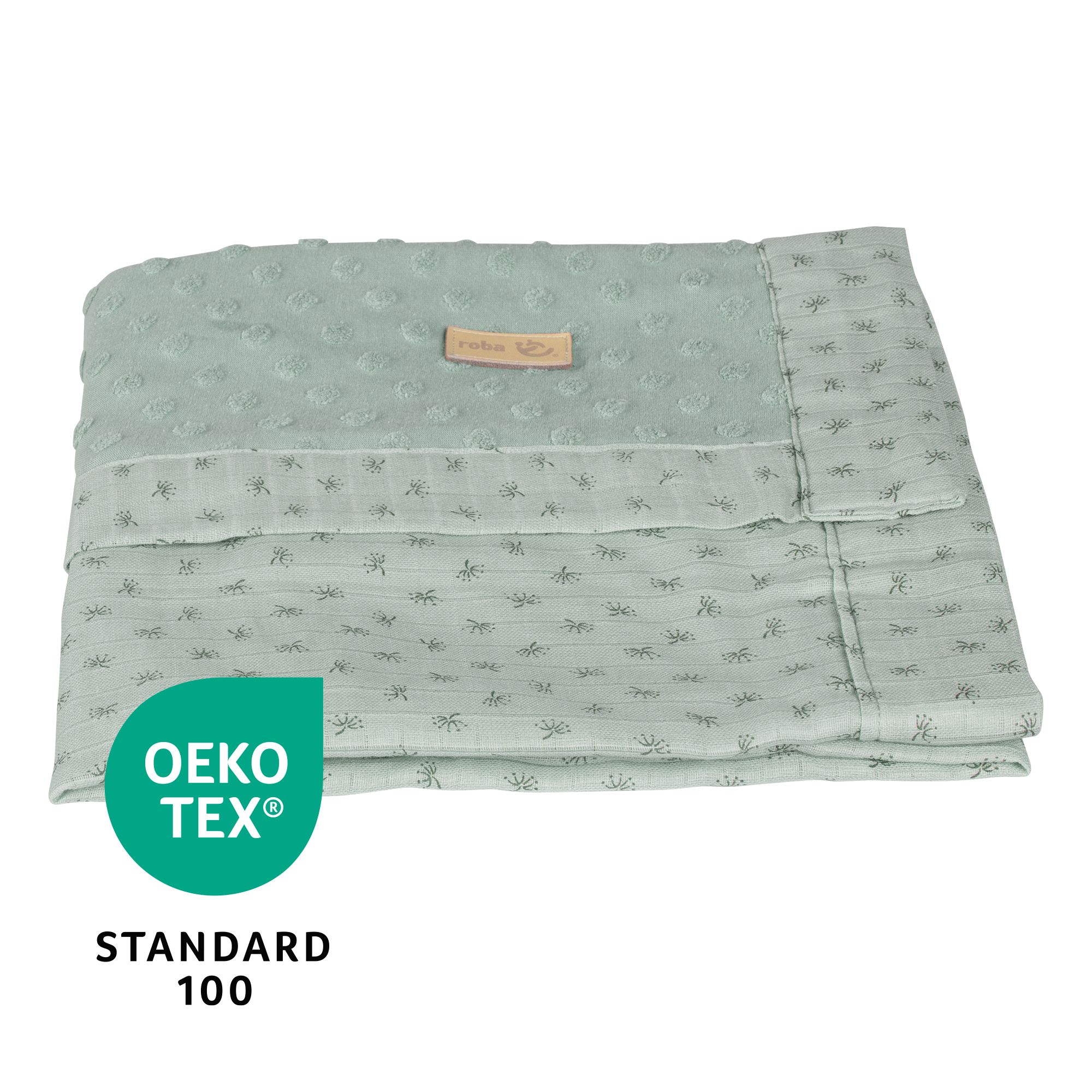 Hellgrüne Babydecke mit gepunktetem Muster. Oeko-Tex Standard 100 Zertifizierung ist sichtbar.