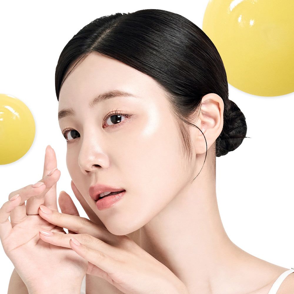 Porträt einer Frau mit glatter Haut. Gelbe Tropfen im Hintergrund. Frau mit hochgesteckten Haaren.