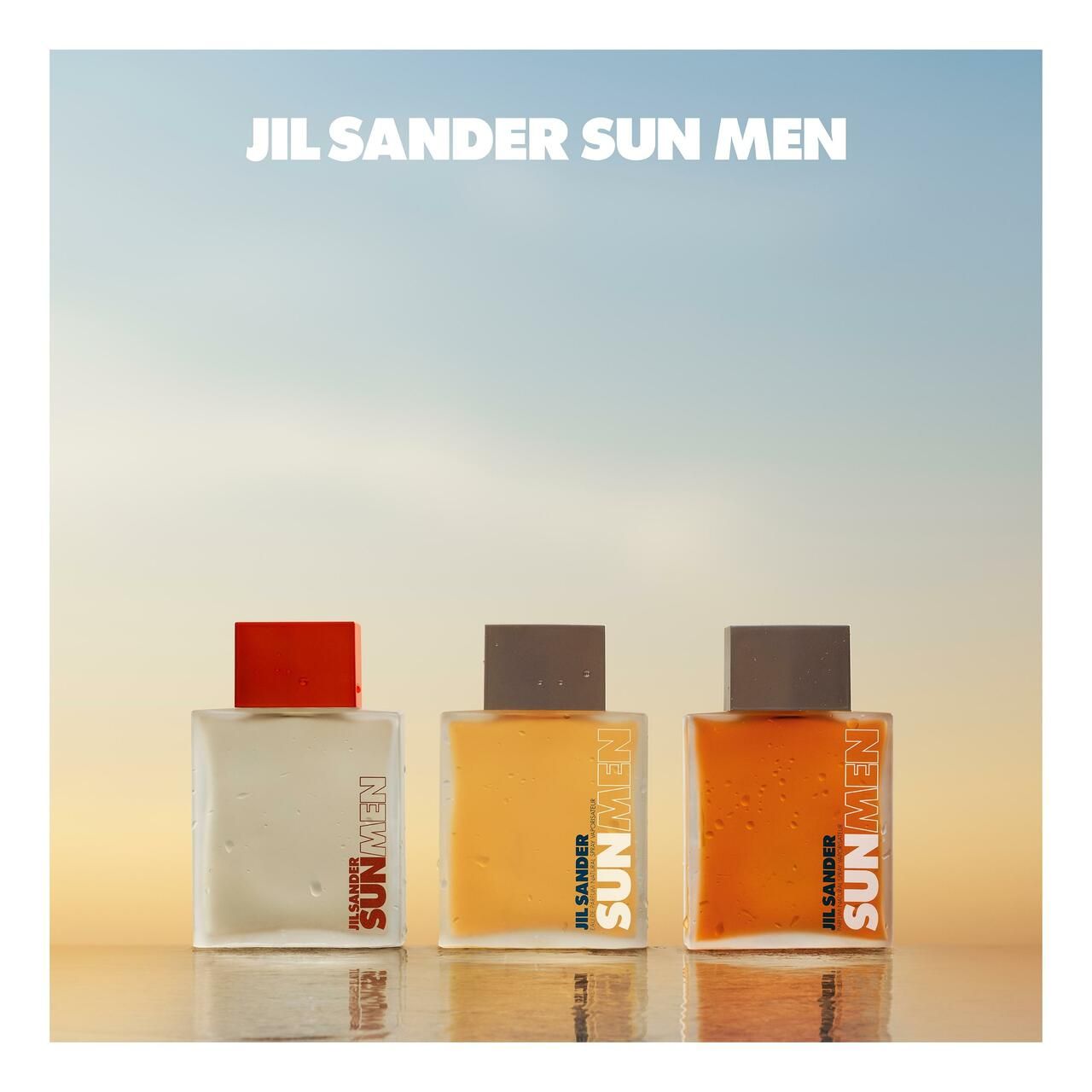 Drei Flakons mit orangefarbenen Deckeln. Aufschrift SUN MEN. Helles, sonniges Hintergrundbild.