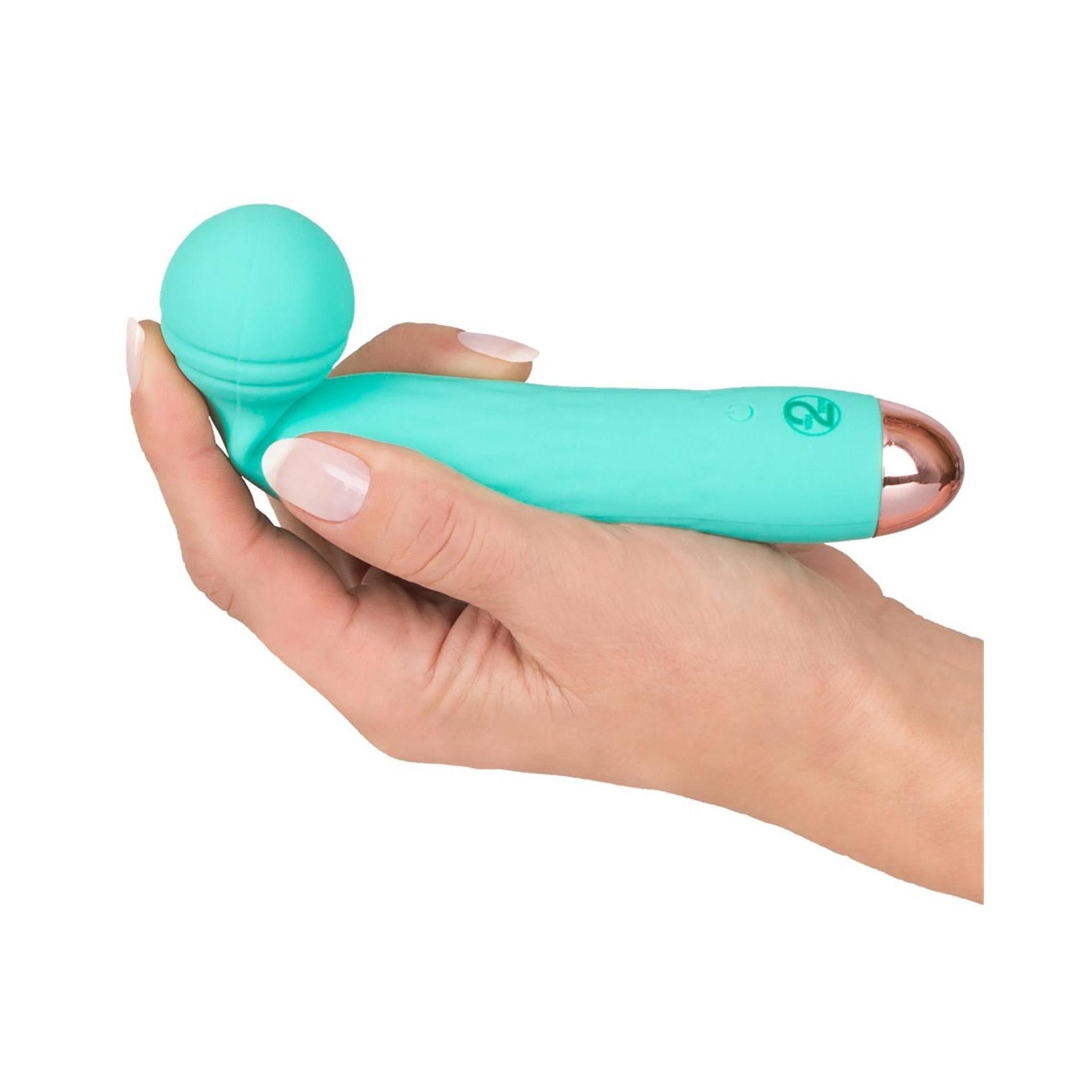 Türkisgrüner Vibrator mit abgerundetem Kopf und goldfarbener Spitze. Gehalten in einer Hand.