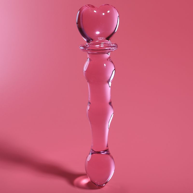 Rosa Glasdildo mit Herzspitze und geschwungenem Griff, Modell 21, auf rosa Hintergrund.