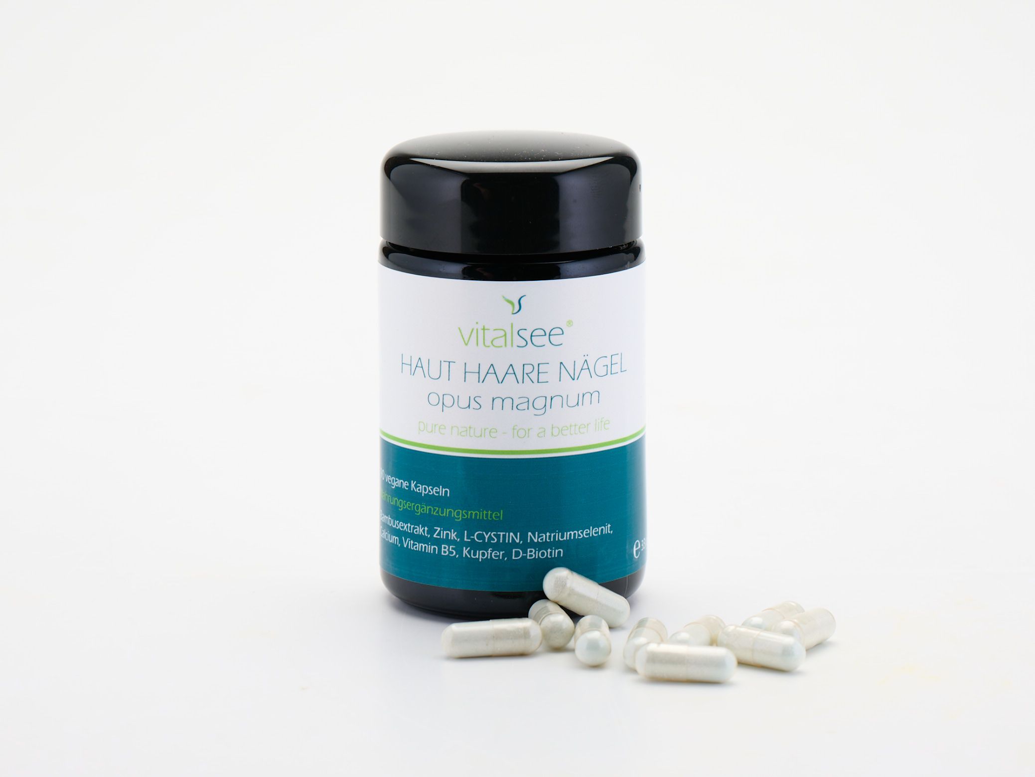 Dose mit schwarzen Deckel und Kapseln daneben. Aufschrift: Vitalsee HAUT HAARE NÄGEL opus magnum. Kapseln.