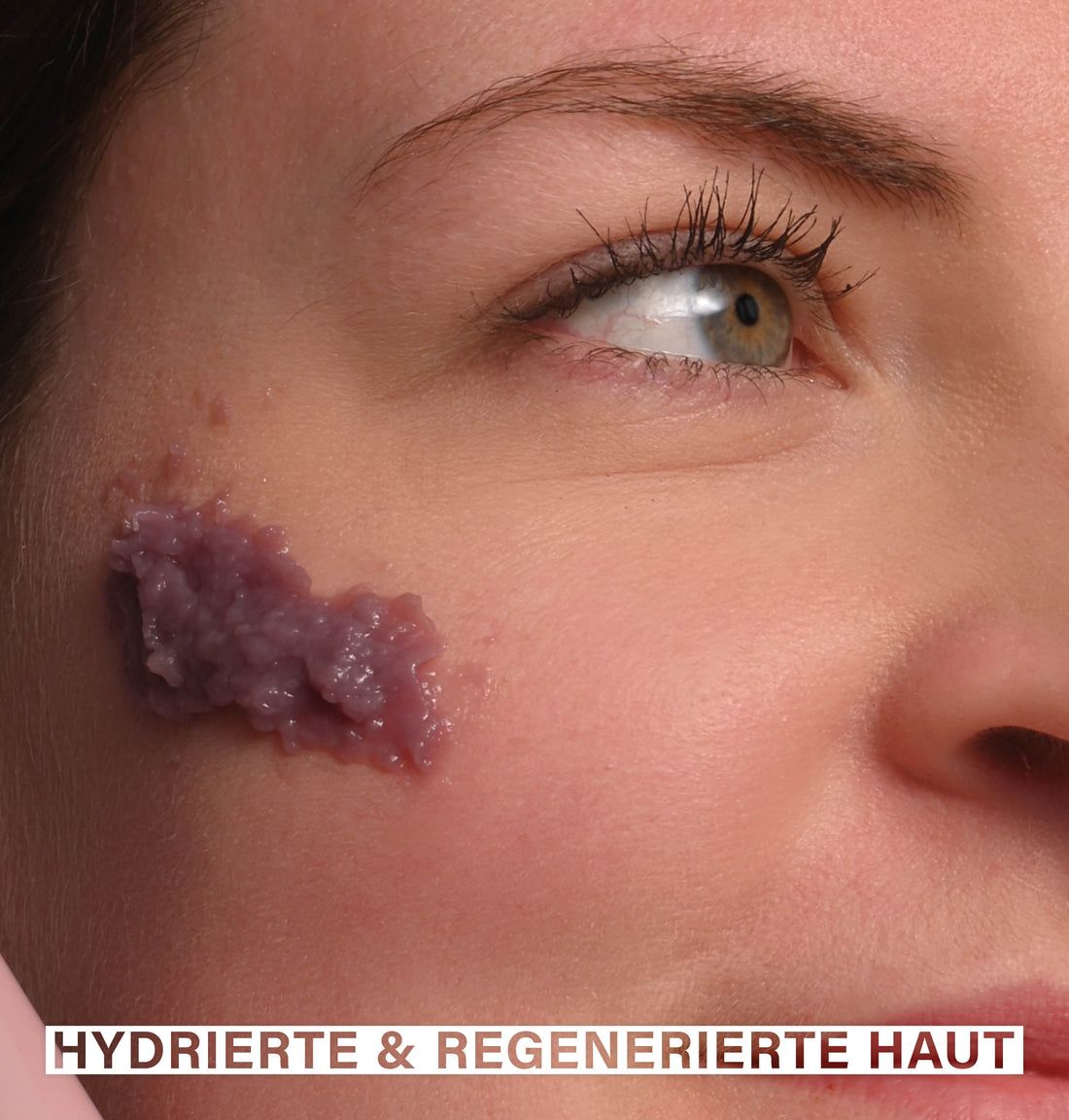 Nahaufnahme eines Gesichts mit Maske. Auf der Haut ist eine violette Maske aufgetragen. Text: Hydrierte & regenerierte Haut.