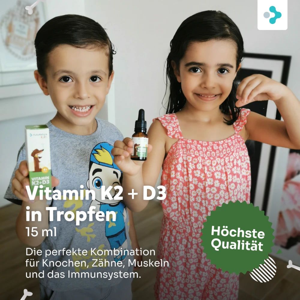 Zwei Kinder halten eine Flasche und eine Packung. Aufschrift: Vitamin K2 + D3 in Tropfen, 15 ml. Grüner Aufkleber: Höchste Qualität.