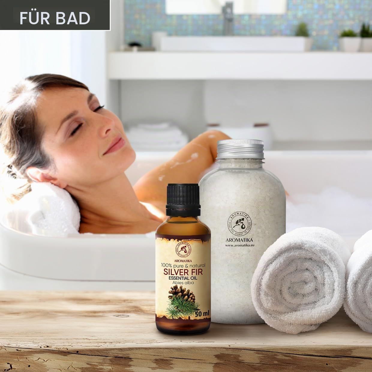 Frau in Badewanne neben Flasche Silber-Tanne-Öl und Badesalz.