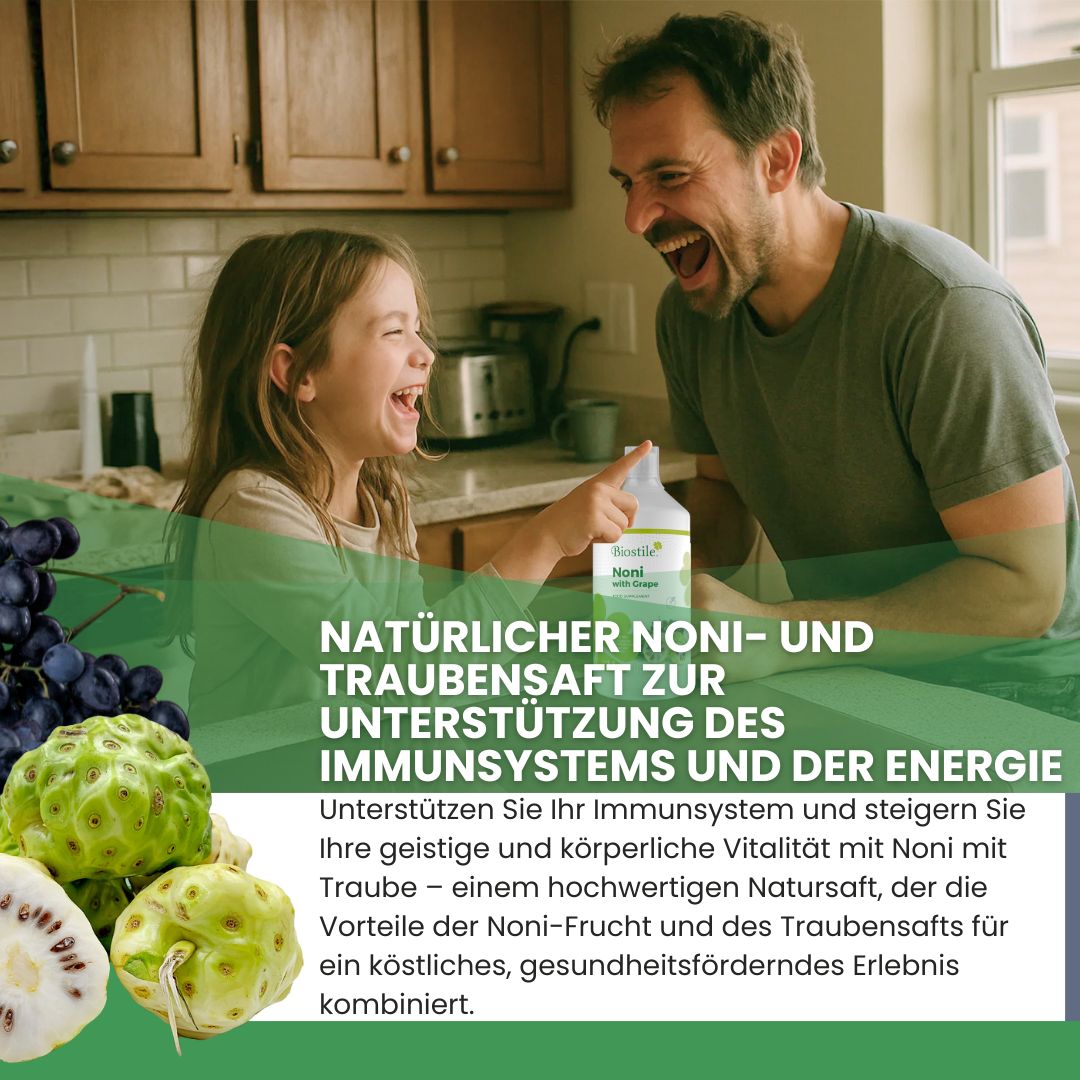 Mann und Kind lachen in der Küche mit einer Flasche Noni-Saft. Noni-Frucht und Trauben im Vordergrund.