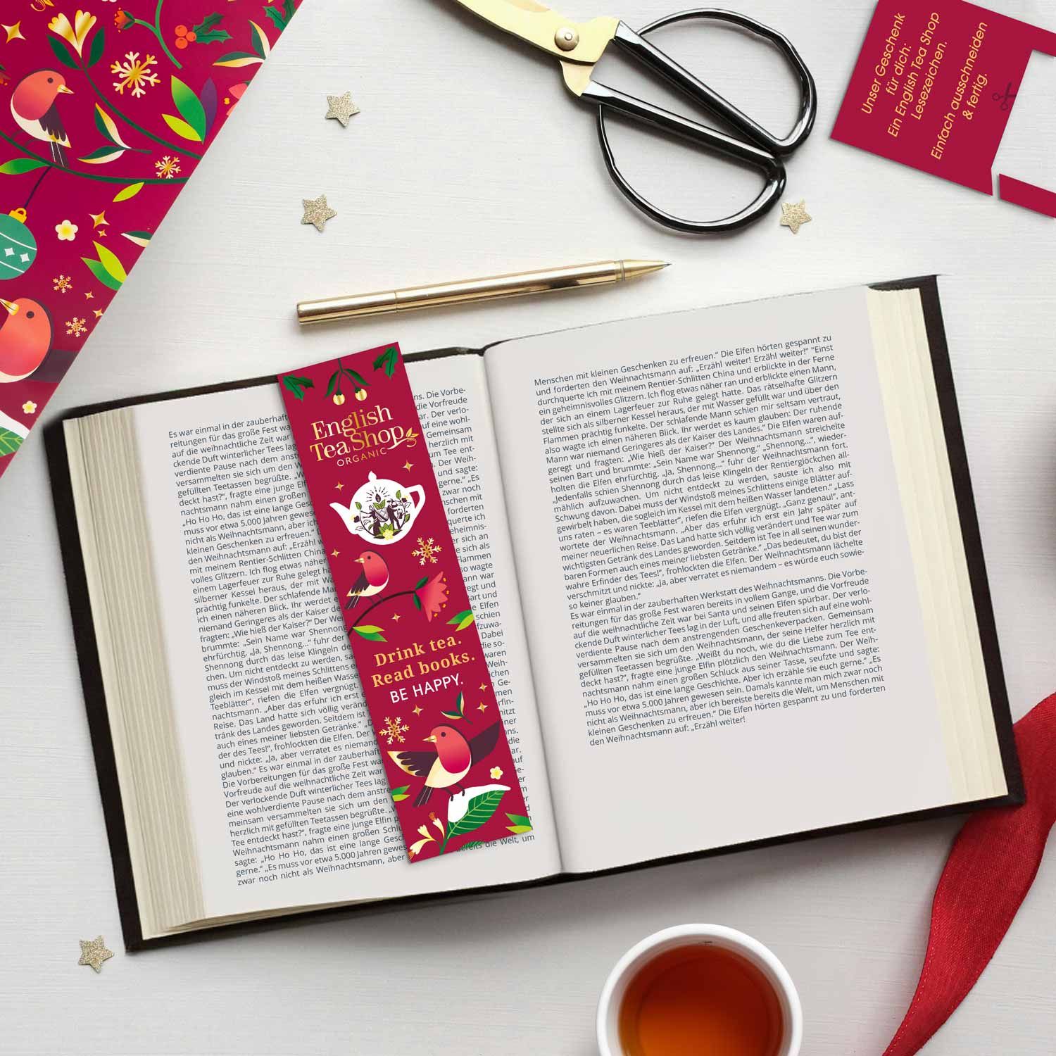 Offenes Buch mit Lesezeichen. Lesezeichen: English Tea Shop, mit Vögeln und Text. Tasse Tee.