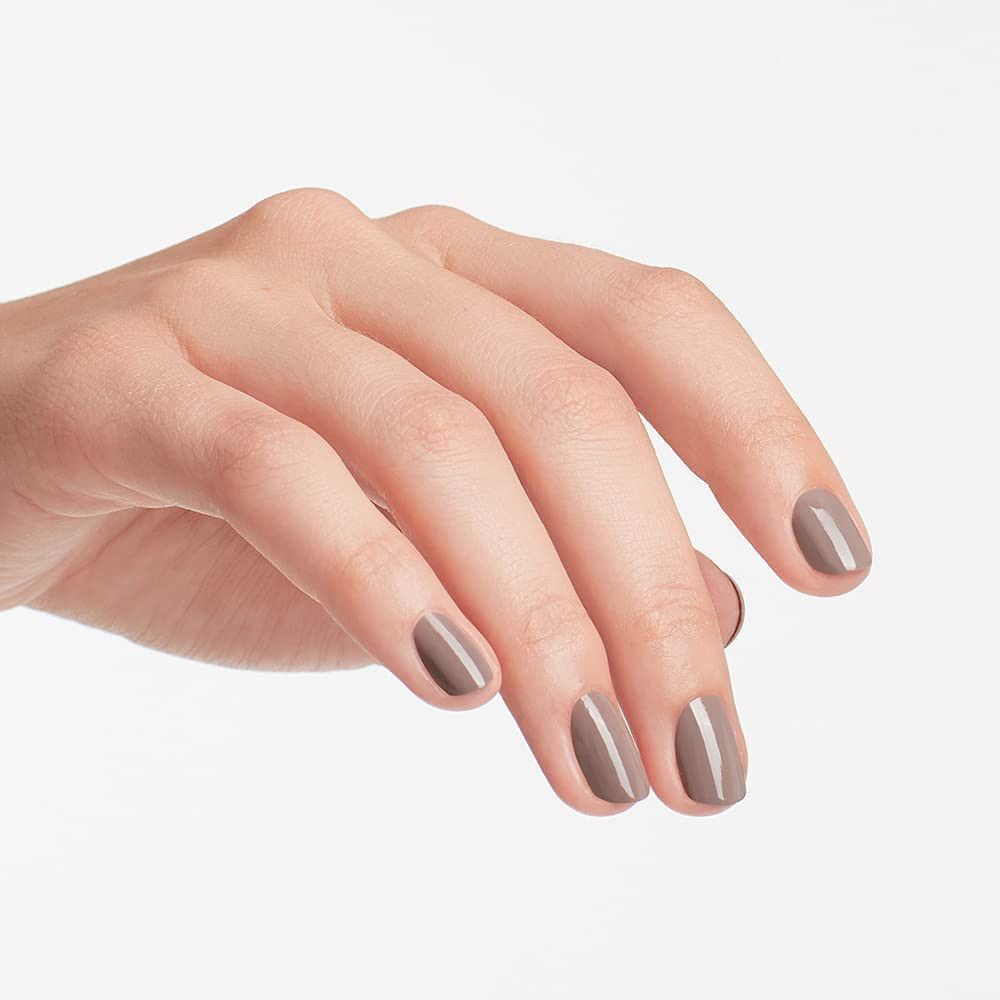 Hand mit lackierten Nägeln in Braun-Grau. Fingernägel mit Nagellack.