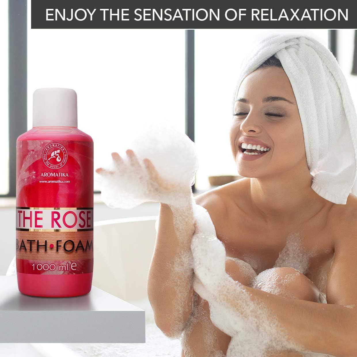 Rosa Flasche AROMATIKA THE ROSE BATH FOAM. Frau mit Schaum in der Hand, lächelt. Badewanne im Hintergrund.