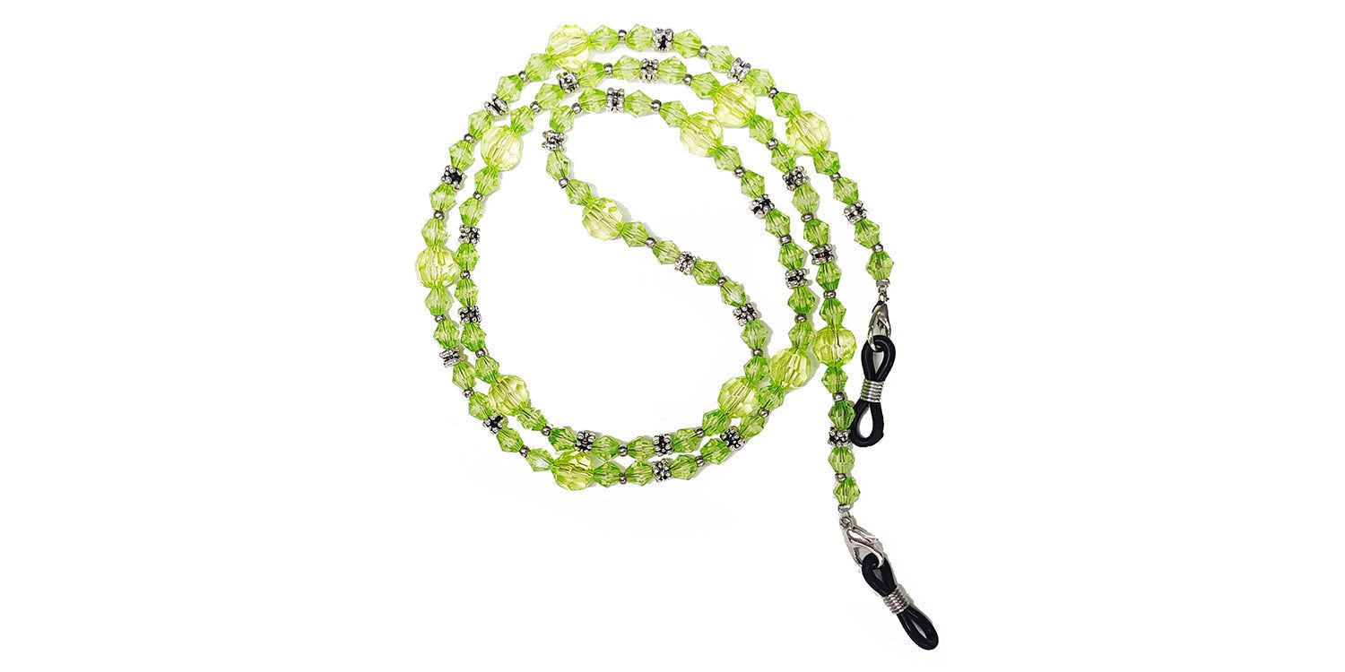 Brillenkette mit grünen Perlen und silberfarbenen Elementen. Die Kette ist mit Brillenhaltern versehen.