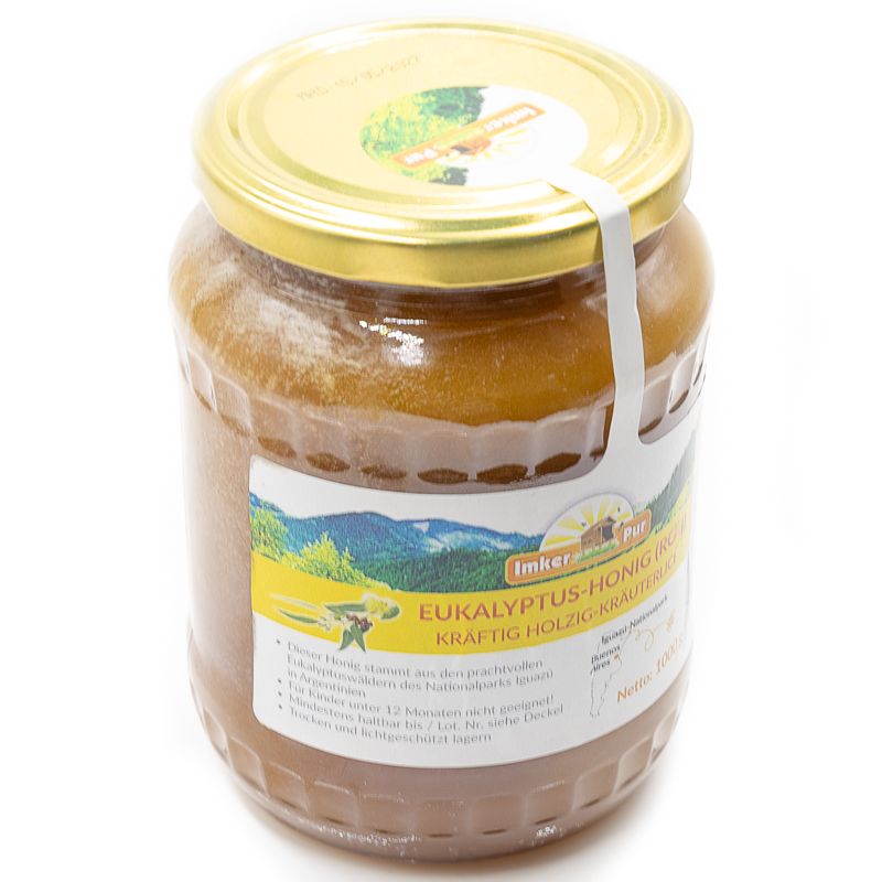 Glas Honig mit Etikett. Aufschrift: Eukalyptus-Honig (roh). Goldfarbener Deckel.