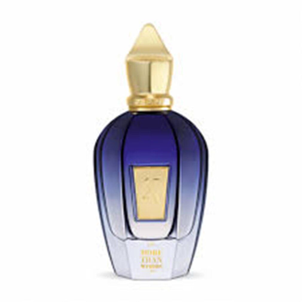 Blau-transparente Flasche mit goldenem Verschluss. Aufschrift "MORE THAN WORDS". Goldfarbenes "X"-Logo.