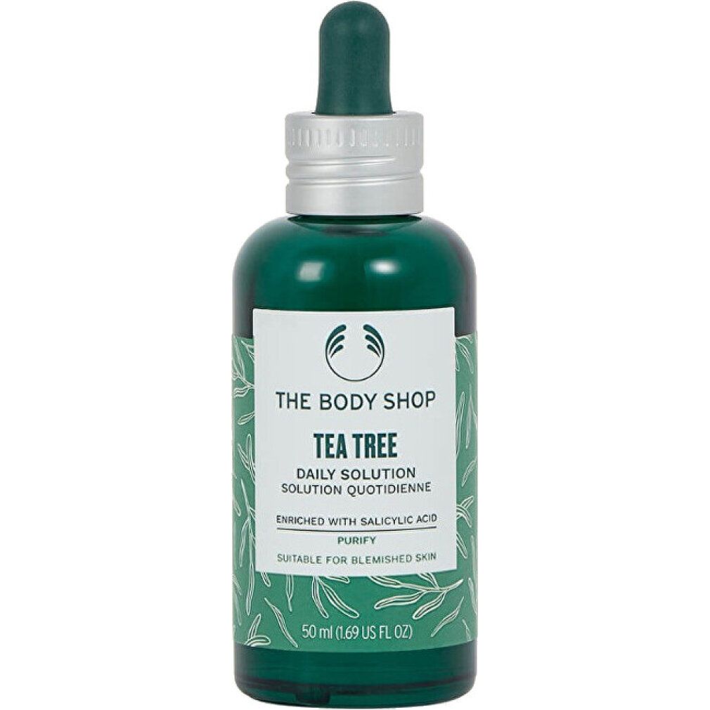 Grüne Flasche mit Pipette. Etikett mit Produktinformationen. "Tea Tree Daily Solution" und "The Body Shop" sind sichtbar.