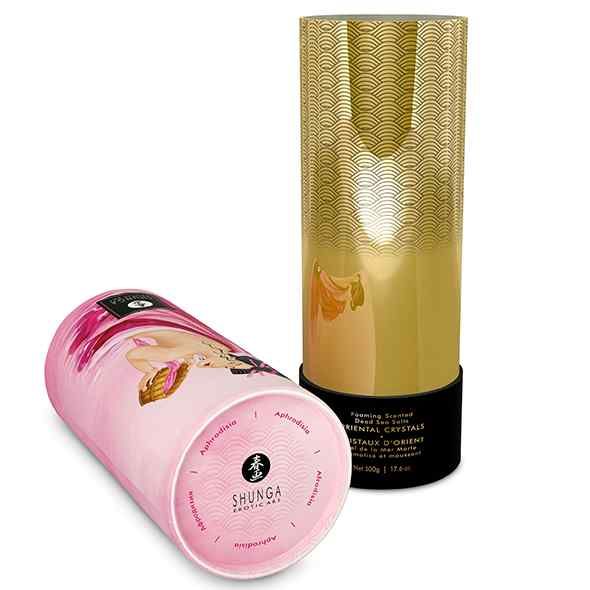 Zwei zylindrische Behälter. Einer ist geöffnet, goldfarben mit Muster. Der andere, rosa, zeigt eine Frau und Produktnamen.