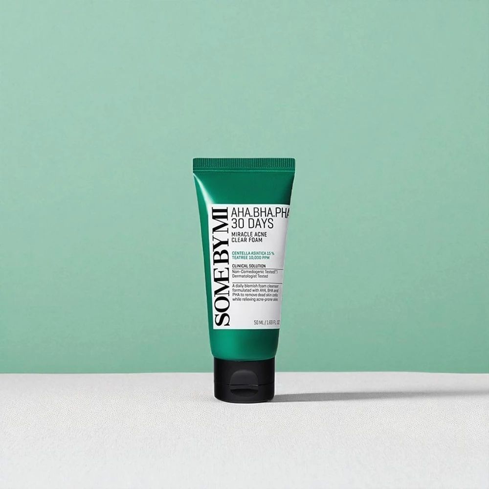 Grüne Tube mit schwarzem Deckel. Text: SOME BY MI, AHA.BHA.PHA 30 Days Miracle Acne Clear Foam. Auf grünem Hintergrund.