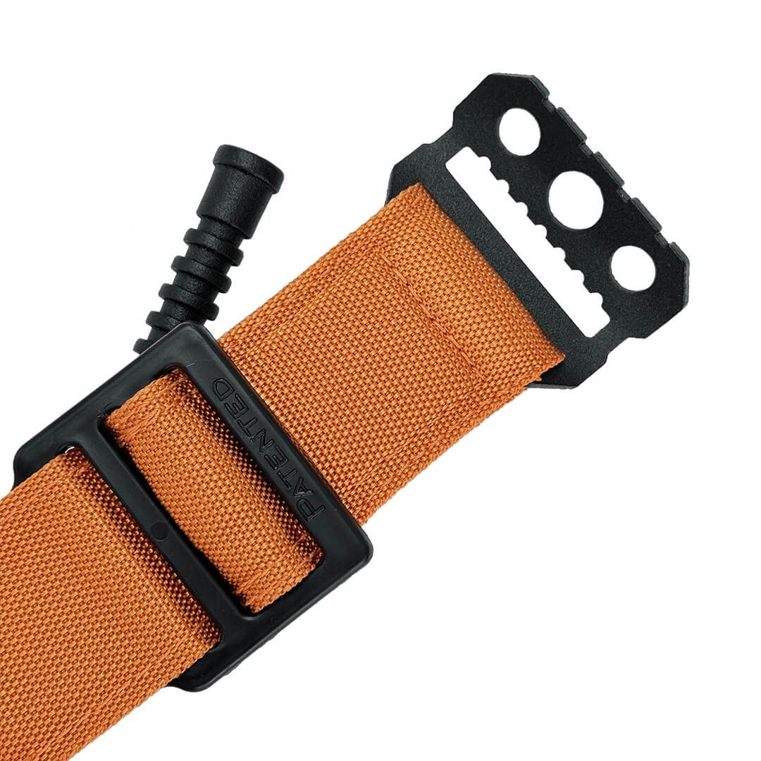 Nahaufnahme des schwarzen Klemmsystems eines orangefarbenen Tourniquets. Patentiert.