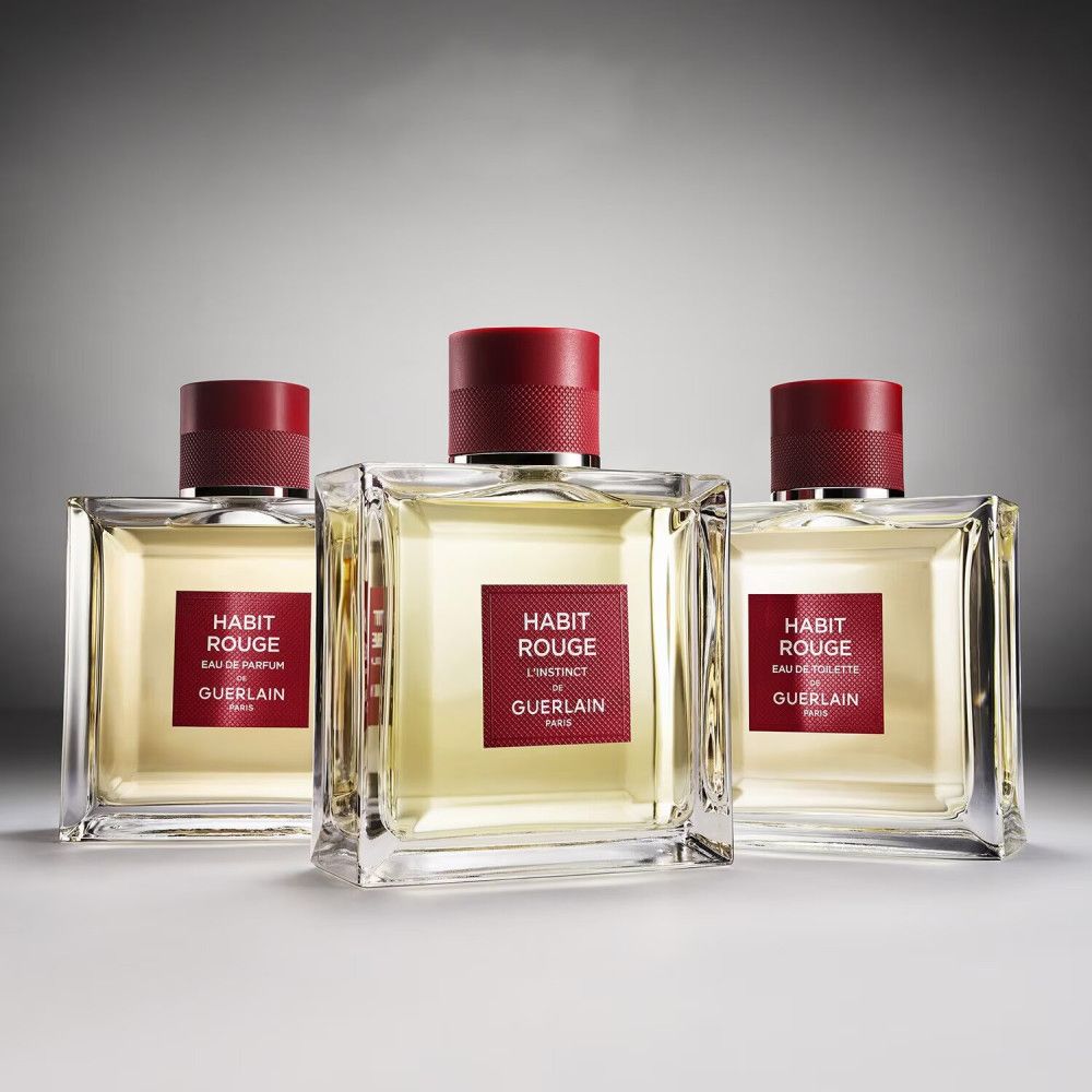 Drei quadratische Flakons mit rotem Verschluss und Etikett. Aufschrift: Habit Rouge Eau de Parfum/Eau de Toilette von Guerlain Paris.