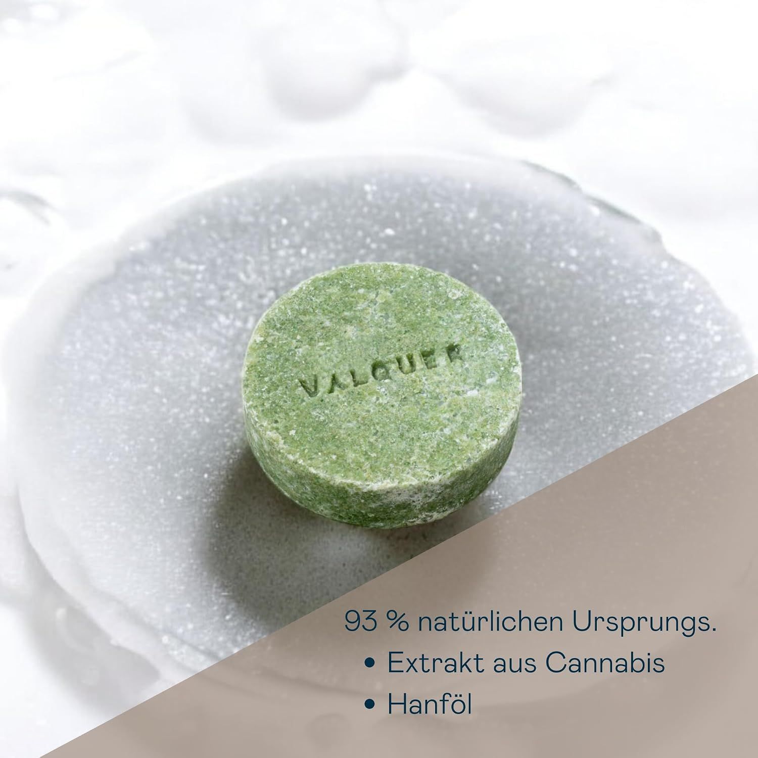 Runder fester VALQUER Shampoo-Bar mit Cannabis-Extrakt auf einem Schaumbett.