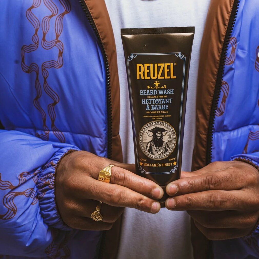 Person hält Reuzel Bartwaschmittel Tube mit Piratenabbildung. 200ml.