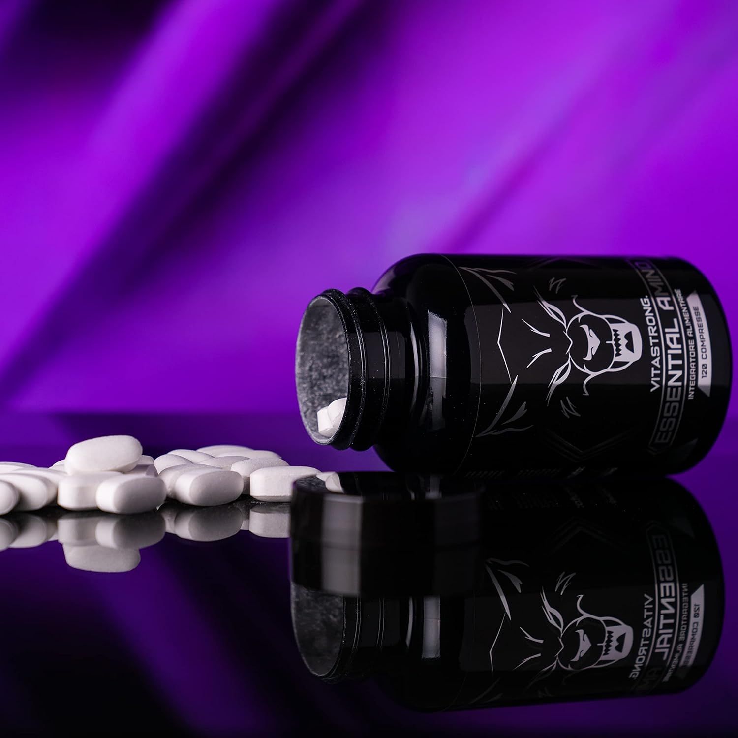 Schwarze Flasche Vitastrong Essential Amino, Tabletten daneben. Aufschrift und Wolf Logo. Lila Hintergrund.