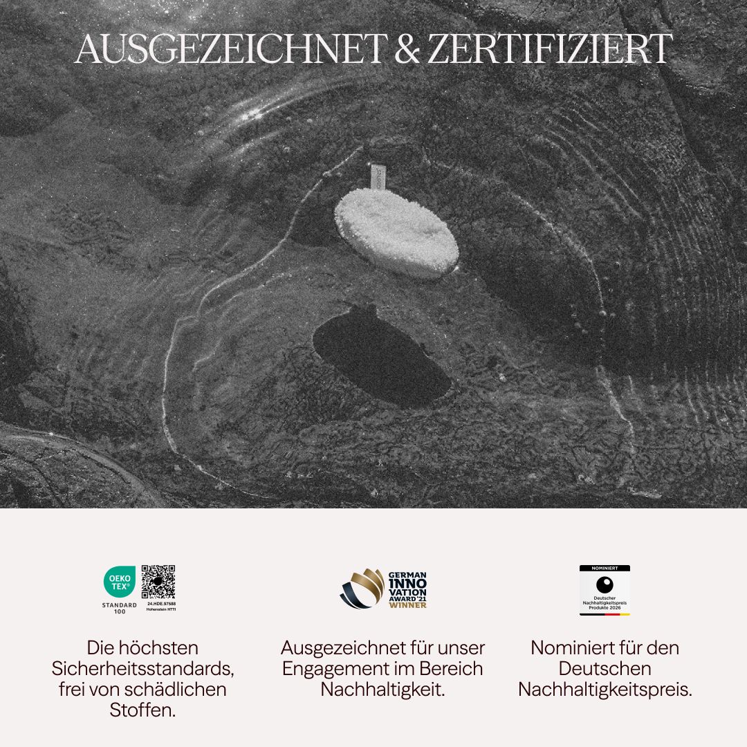 Ein weißes, rundes Pad liegt auf einer eisigen Oberfläche. Logos und Text zeigen Zertifizierungen und Auszeichnungen.