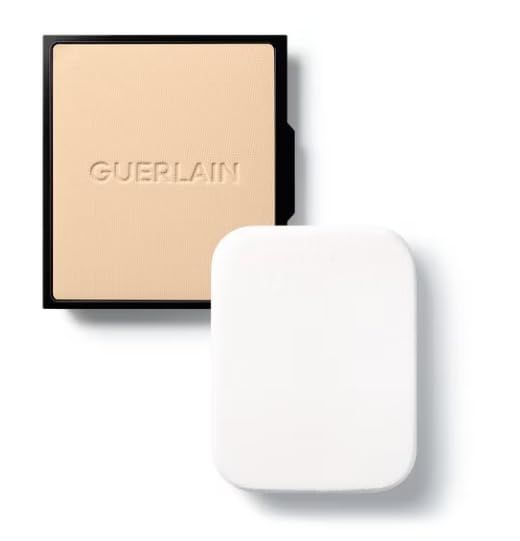 Kompakt-Foundation und Schwamm. Schwarze Kompakt-Foundation mit Schriftzug Guerlain. Weißer Schwamm daneben.