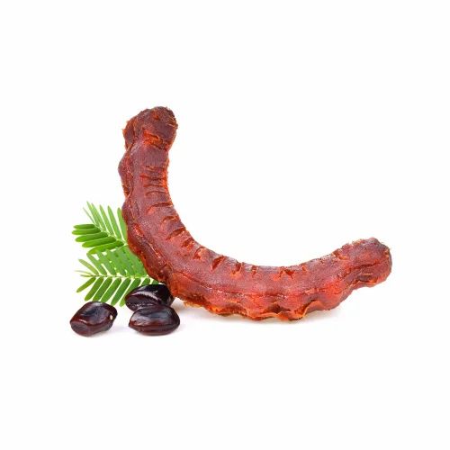 Ein Tamarindenfrucht, braun und gebogen, mit grünen Blättern und einigen Samen auf weißem Hintergrund. Die Frucht hat eine längliche Form und eine unregelmäßige Oberfläche.