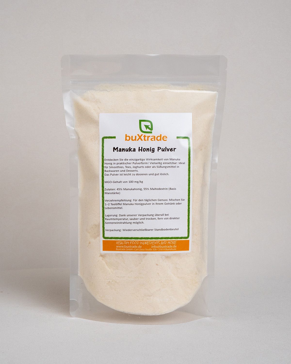 Beutel mit Pulver. Aufdruck: buXtrade Manuka Honig Pulver. Grün-oranges Etikett mit Text.