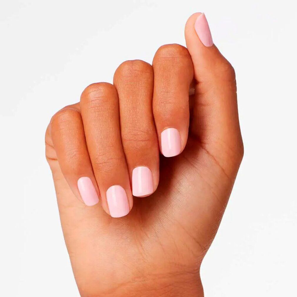 Hand mit lackierten Nägeln. Rosa Nagellack auf allen Fingern. Klare, gleichmäßige Anwendung.