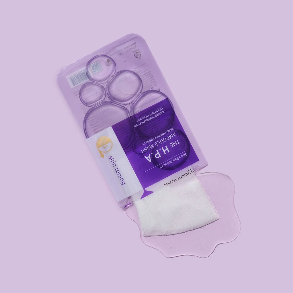 Ausgelaufene Flüssigkeit und Wattepad neben der Verpackung. Text: THE H.P.A AMPOULE MASK, skin toning.