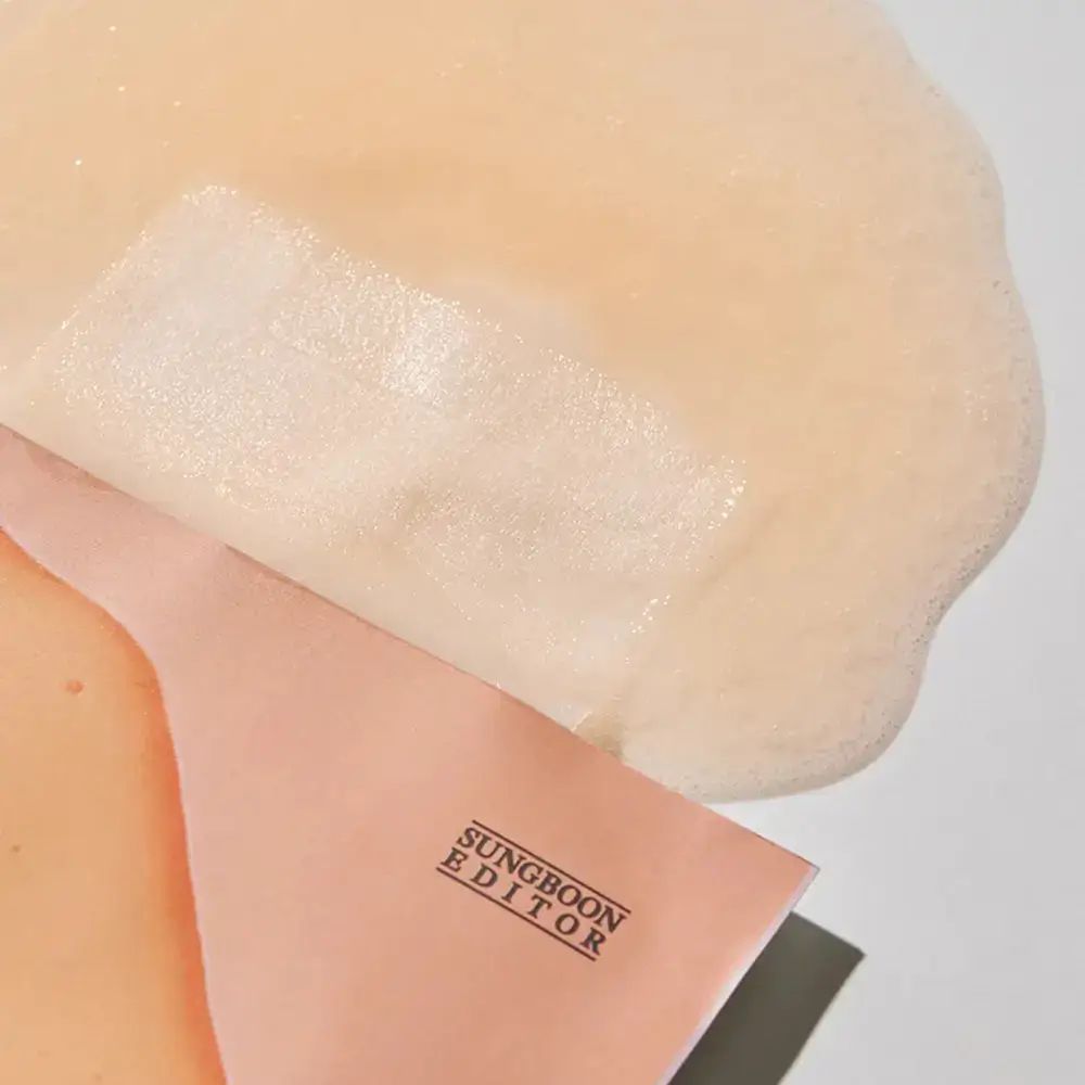 Gesichtsmaske teilweise entfaltet. Marke: SUNGBOON EDITOR. Rosa Verpackung.