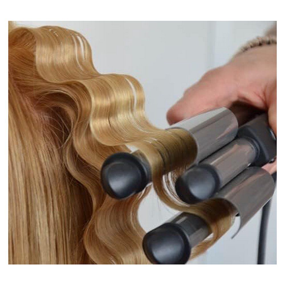 Anwendung eines Babyliss Lockenstabs auf blondem Haar für Wellen.