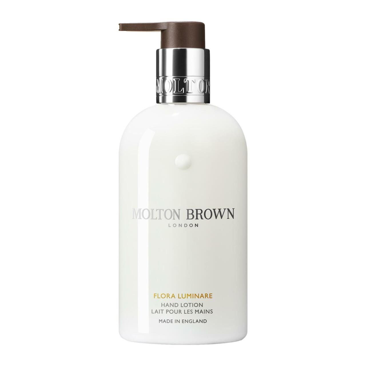 Weiße Flasche Molton Brown Flora Luminare Handlotion mit Pumpe. Silberner Pumpkopf, braune Spitze. Produktname und Marke sichtbar.