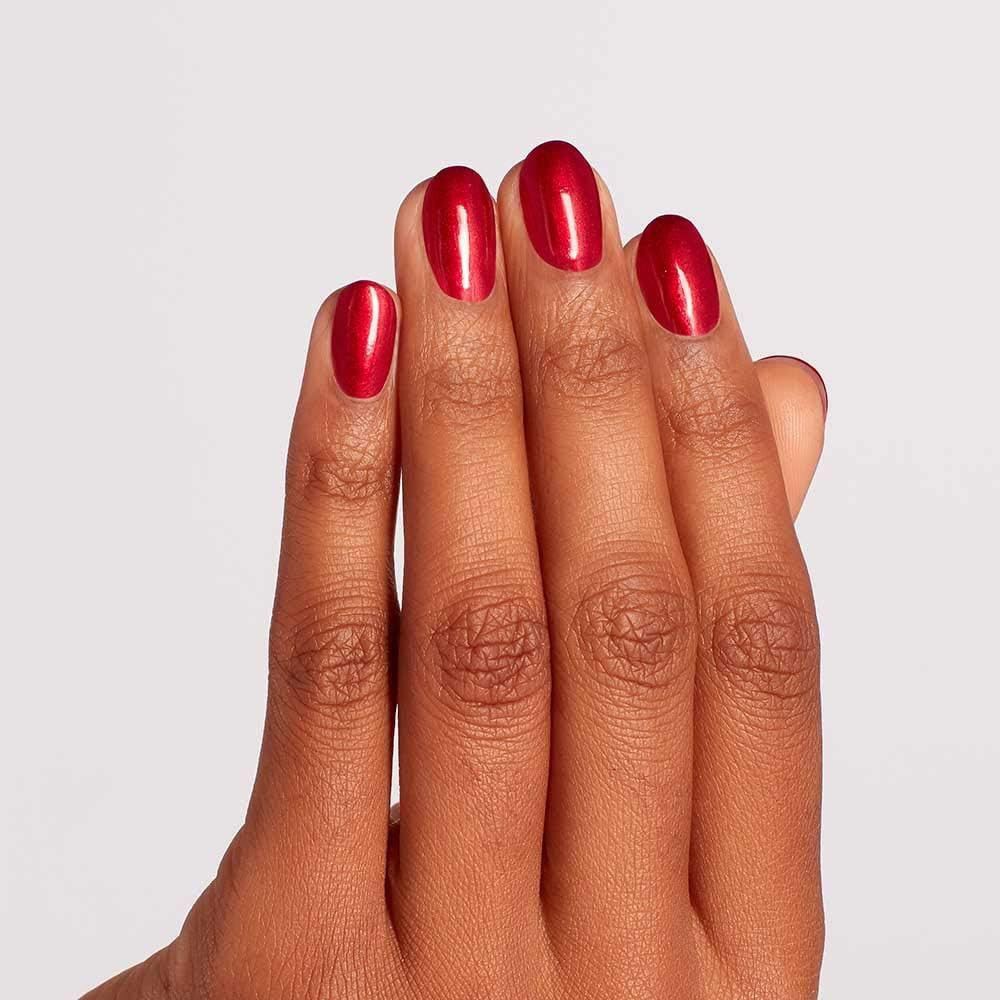 Hand mit lackierten Nägeln. Die Nägel sind rot und glänzend.