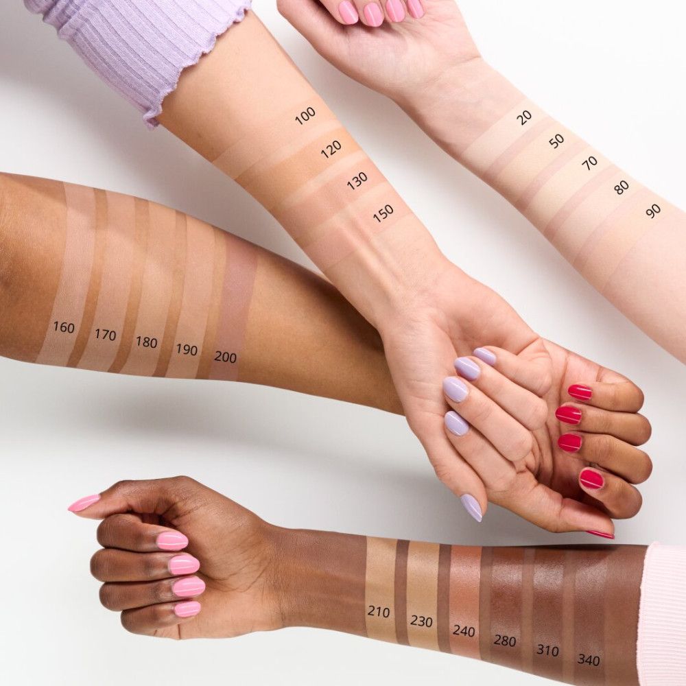 Arme mit verschiedenen Hauttönen, auf denen Concealer-Farben aufgetragen sind. Zahlen kennzeichnen die Farbtöne. Verschiedene Nagellackfarben.