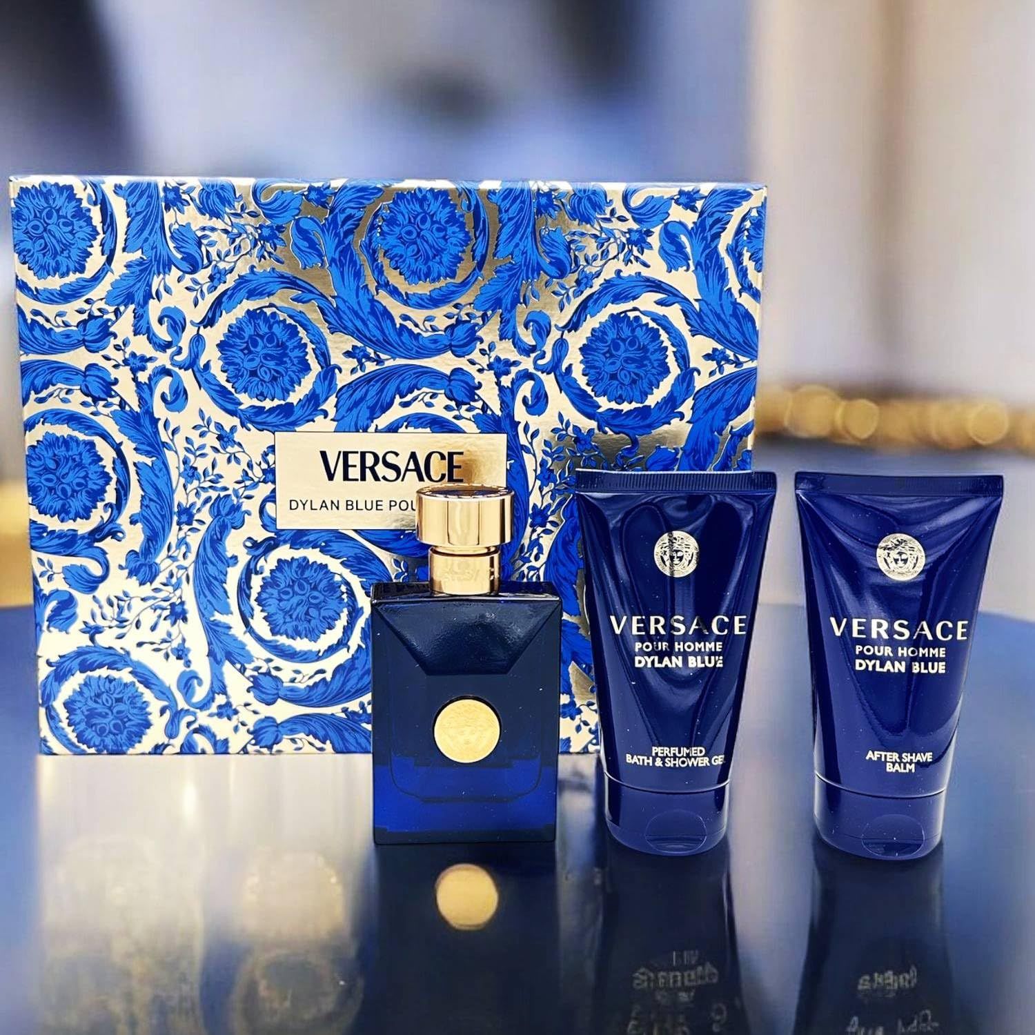 Geschenkbox mit blauem Muster, enthält eine blaue Flasche und zwei blaue Tuben. Das Versace-Logo ist sichtbar.