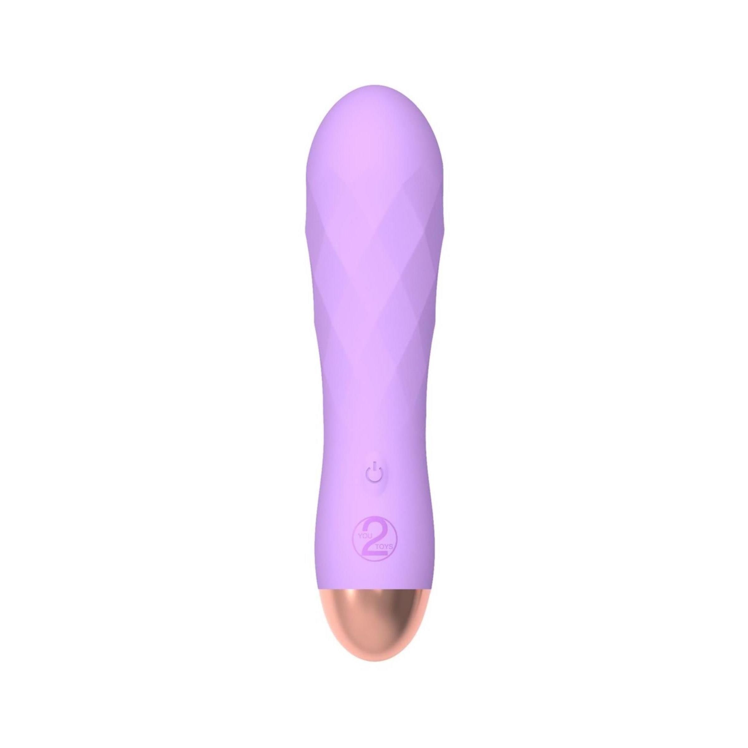 Lila Vibrator mit geriffelter Oberfläche, goldfarbener Spitze und Bedienknöpfen. Auf weißem Hintergrund.