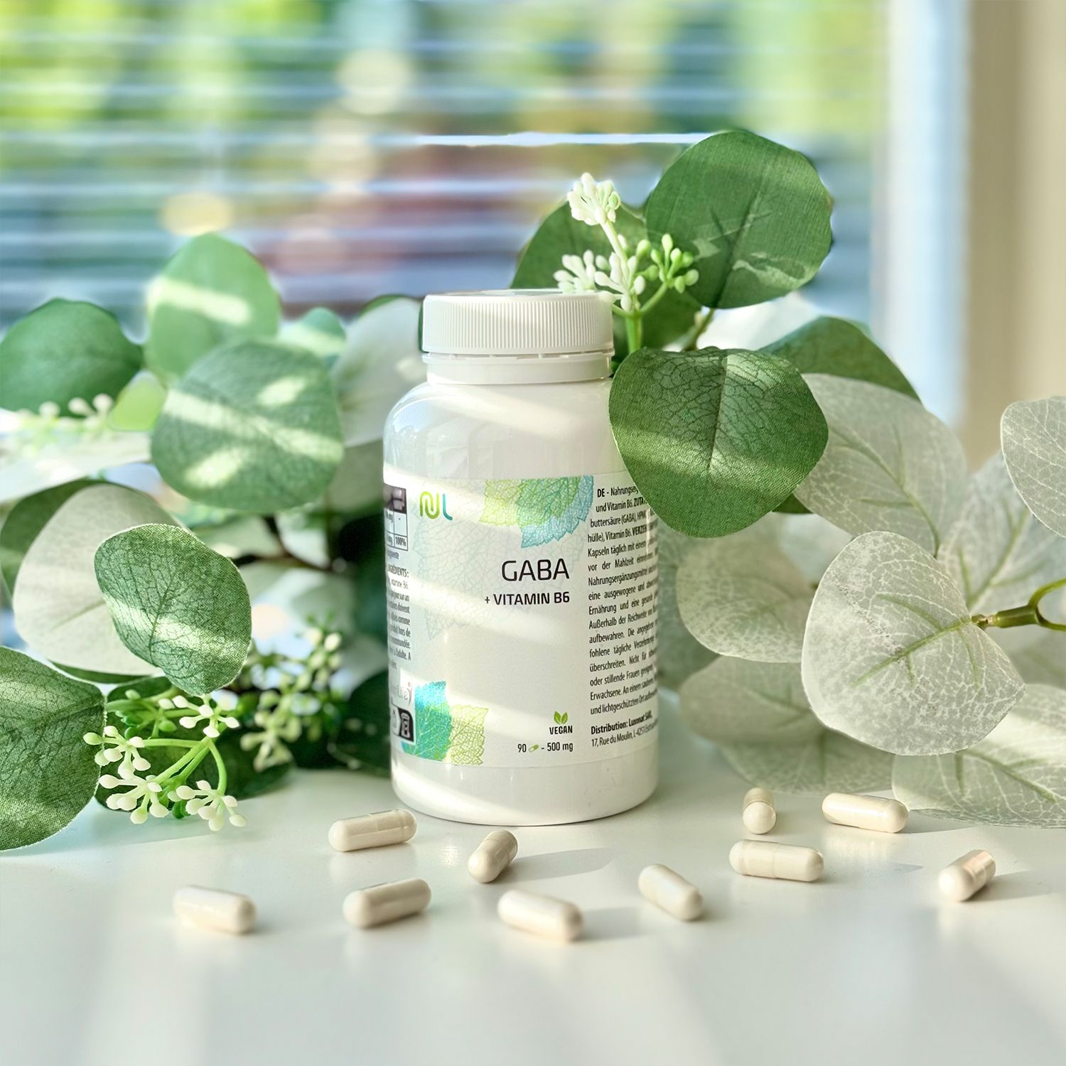 Weiße Flasche mit Kapseln. Aufschrift: Gaba + Vitamin B6. Vegan-Siegel. Kapseln liegen verstreut.