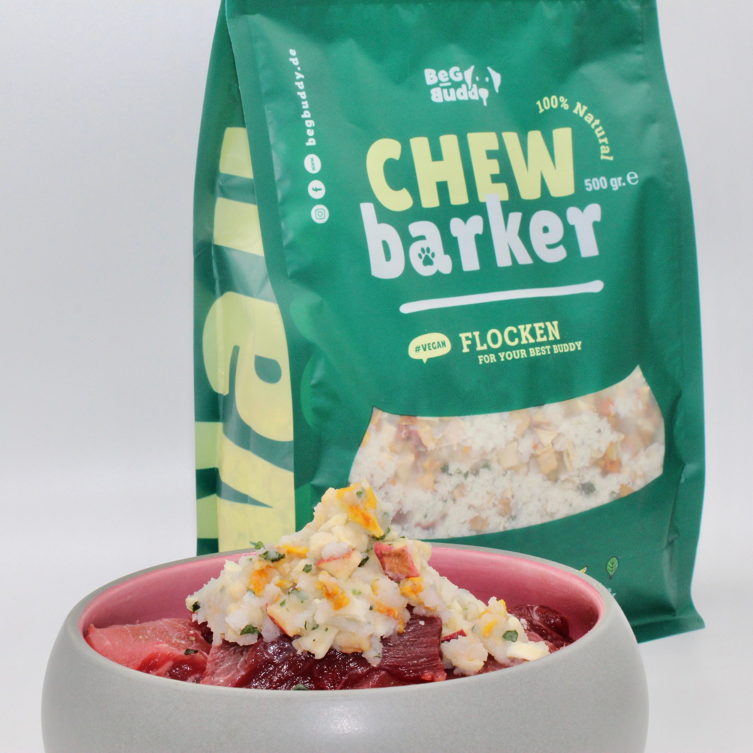 Schüssel mit Fleisch und Flocken. Grüne Verpackung "Chew Barker" im Hintergrund.